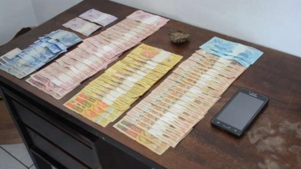 Com o jovem, foram encontrados 29 gramas de maconha e R$ 1.920,00 em dinheiro. (Foto: PM)